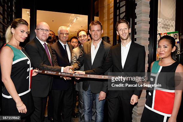 Heuer's CEO Stephane Linder, Antonio Belloni, Sebastien Ogier and Romain Grosjean cut the ribbon at the Opening of the TAG Heuer New Boutique,...
