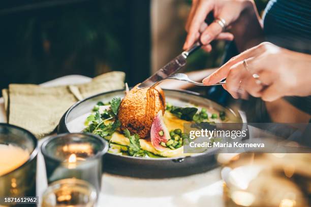 a woman eats delicious food during a date in a restaurant. - serving size stock pictures, royalty-free photos & images