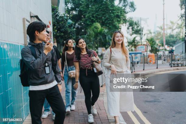 a chinese tour guide explaining to tourists with mixed nationalities about the history of the aberdeen's fishing port - indian tour guide stock pictures, royalty-free photos & images