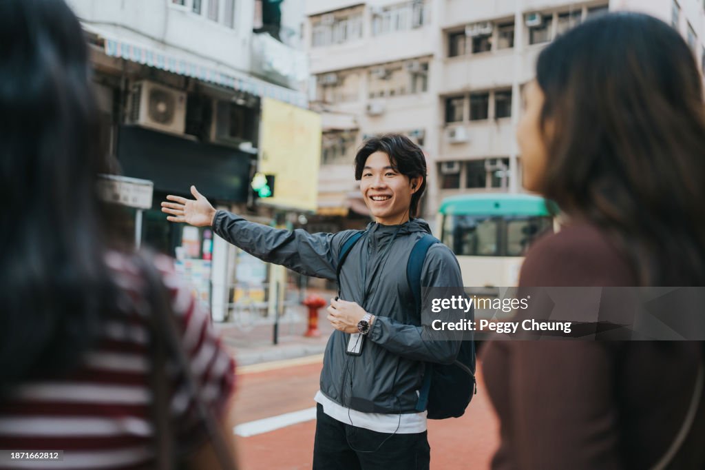 A smiling Chinese tour guide pointing directions to tourists
