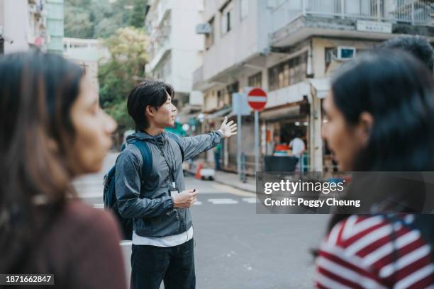 a chinese male tour guide showing directions - indian tour guide stock pictures, royalty-free photos & images