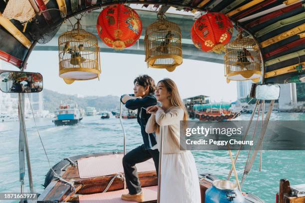 ein chinesisches paar genießt die atemberaubende aussicht vom sampan-boot aus - insel hong kong island stock-fotos und bilder
