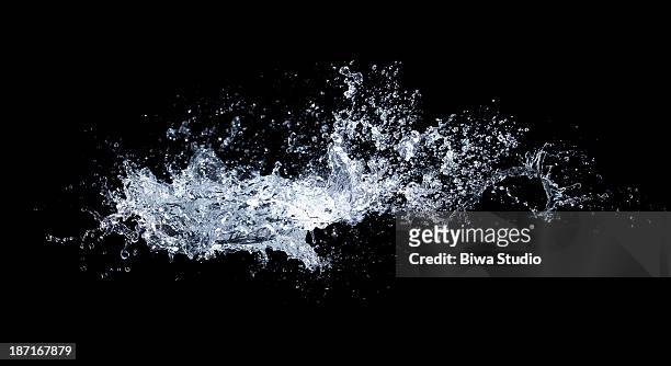 water splash in midair on black background - water stock-fotos und bilder
