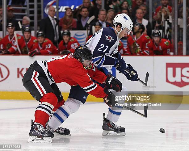 Nick Leddy of the Chicago Blackhawks defends against Eric Tangradi of the Winnipeg Jets at the United Center on November 6, 2013 in Chicago, Illinois.