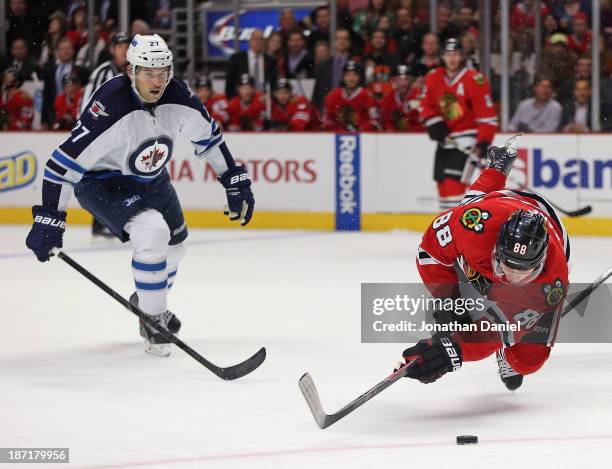 Patrick Kane of the Chicago Blackhawks falls to the ice after being tripped by Eric Tangradi of the Winnipeg Jets at the United Center on November 6,...