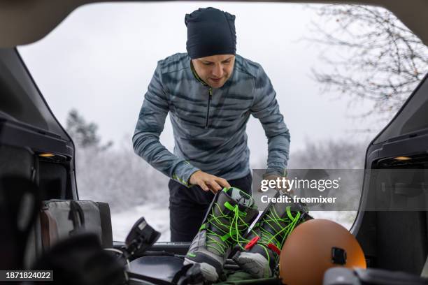 man preparing for snowboarding - white snowboard boots stock pictures, royalty-free photos & images