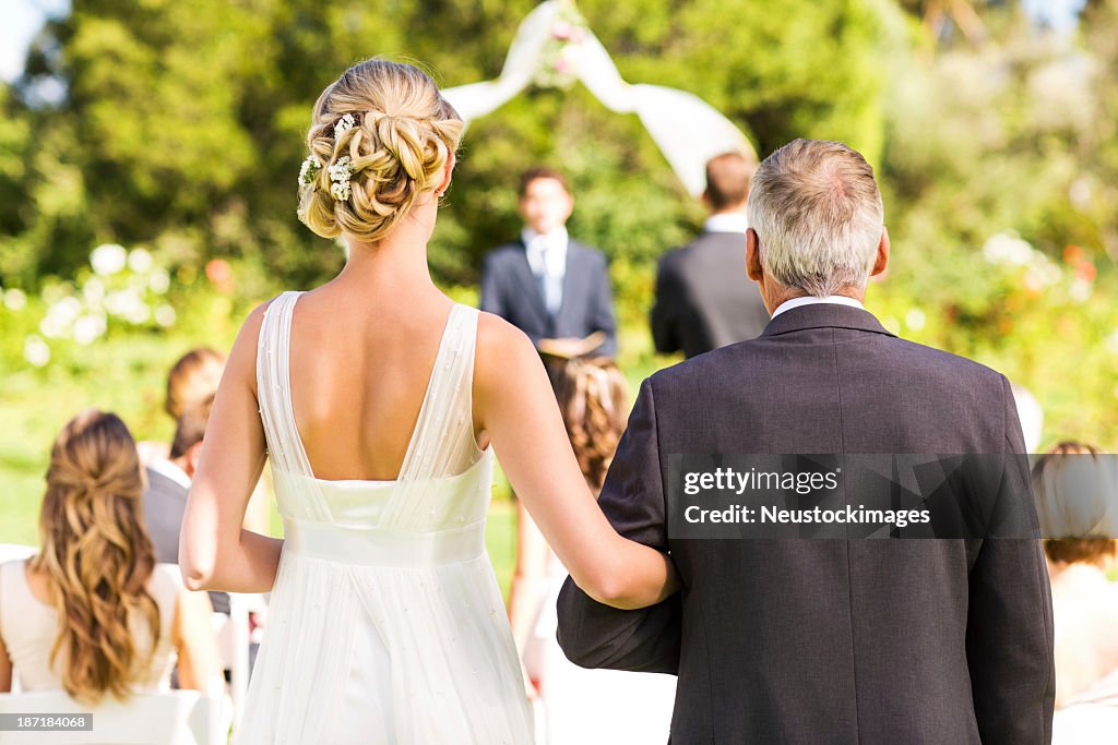 Braut und Vater zu Fuß zum Traualtar bei Hochzeit im Freien