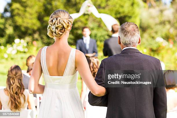 braut und vater zu fuß zum traualtar bei hochzeit im freien - wedding ceremony stock-fotos und bilder