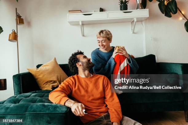 young couple chilling in a living room - young couple stock pictures, royalty-free photos & images