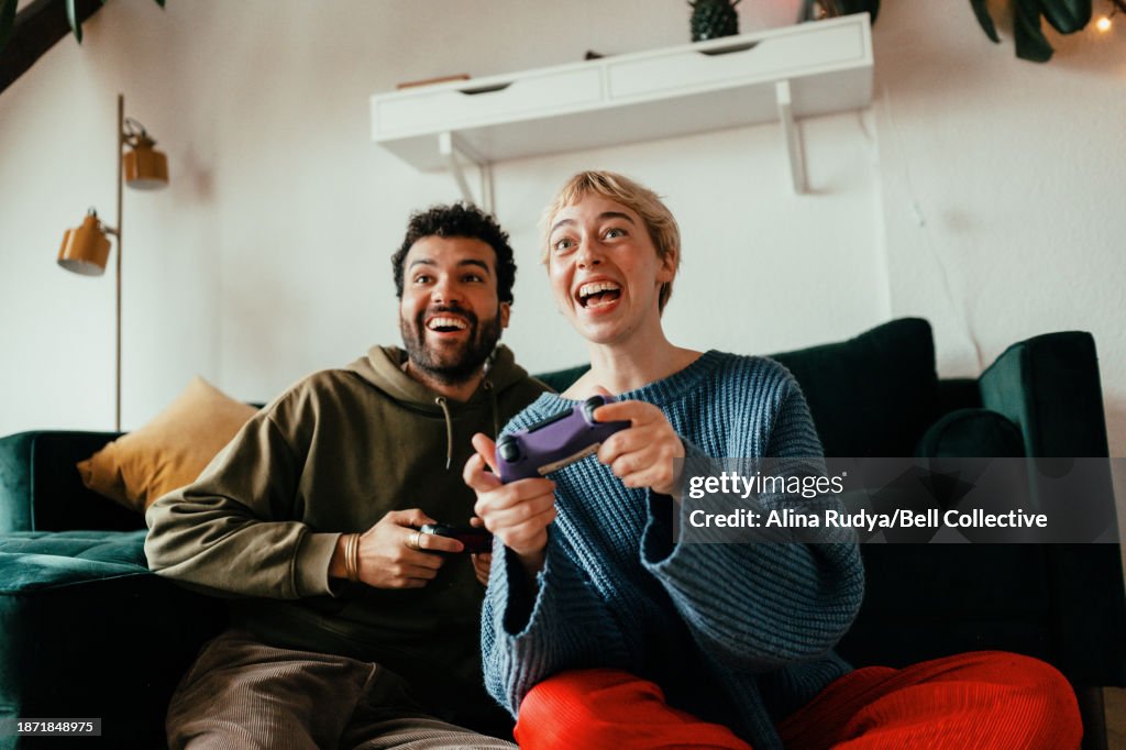 Young couple playing video games on a console