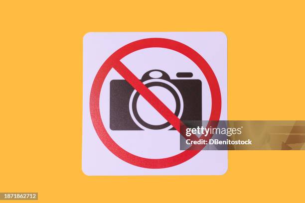 sign prohibiting taking photos in which a camera and the prohibited sign appear, on a yellow background. concept of prohibition, copyrights, image rights, photography. - restricted area sign ストックフォトと画像