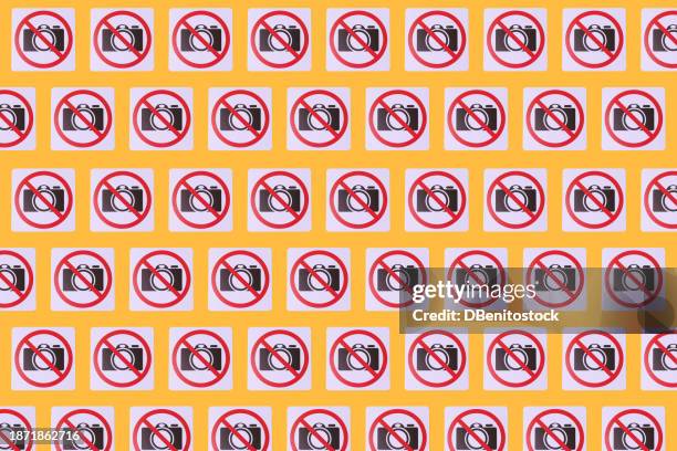 pattern of signs prohibiting taking photos in which a camera and the prohibited sign appear, on a yellow background. concept of prohibition, copyrights, image rights, photography. - health and safety icons stock pictures, royalty-free photos & images