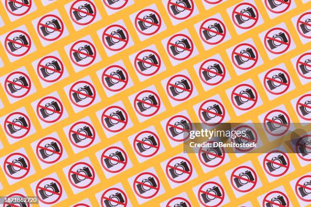 pattern of signs prohibiting taking photos in which a camera and the prohibited sign appear, on a yellow background. concept of prohibition, copyrights, image rights, photography. - health and safety icons stock pictures, royalty-free photos & images