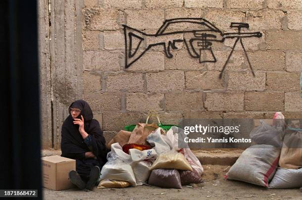 Palestinian refugee woman waits for food distribution at the UNRWA distribution center in the Khan Younis refugee camp on December 14 with a machine...