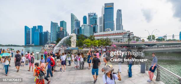 singapore crowds of tourists marina bay below skyscrapers panorama - merlion park singapore stock pictures, royalty-free photos & images