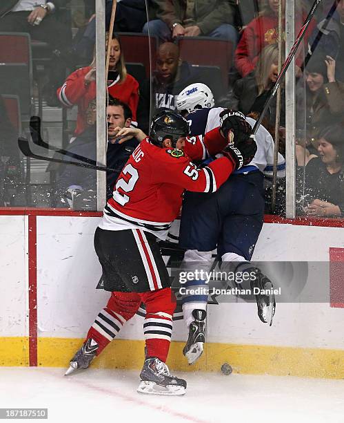 Brandon Bollig of the Chicago Blackhawks checks Adam Pardy of the Winnipeg Jets through the glass at the United Center on November 6, 2013 in...