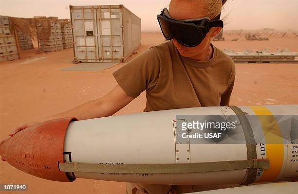 Senior Airman Lisa Jones, a precision guided munitions crewmember protective covers on missles in preparation for a mission in Operation Iraqi...