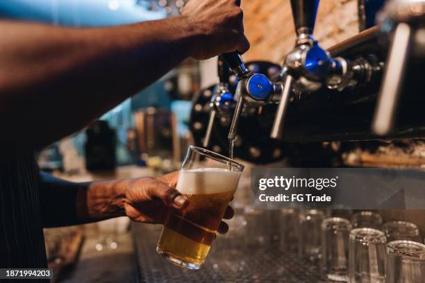 close-up of a bartender pouring a draught lager beer - brouwerij stockfoto's en -beelden