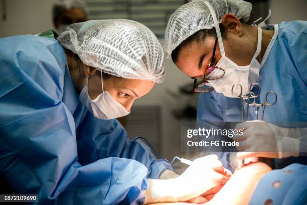doctors doing a cesarean section at hospital - c section stock pictures, royalty-free photos & images