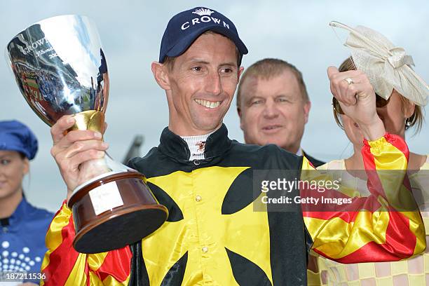 Nash Rawiller poses with the trophy after Kirramosa won Race 6 the Crown Oaks during Oaks Day at Flemington Racecourse on November 7, 2013 in...