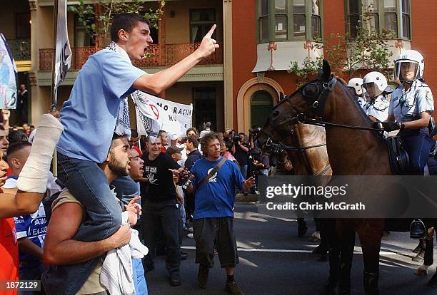 An anti-war protester screams at mounted police in Sydney's Central Business district on March 26, 2003 in Sydney, Australia. 20,000 school children...