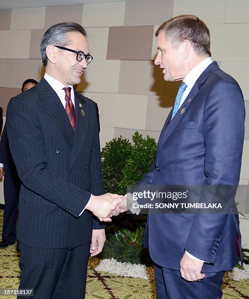 Indonesian Foreign Minister Marty Natalegawa shakes hands with UK Secretary of State for Wales David Jones before a bilateral meeting at the Bali...