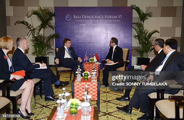 Indonesian Foreign Minister Marty Natalegawa speaks with UK Secretary of State for Wales David Jones during a bilateral meeting at the Bali Democracy...
