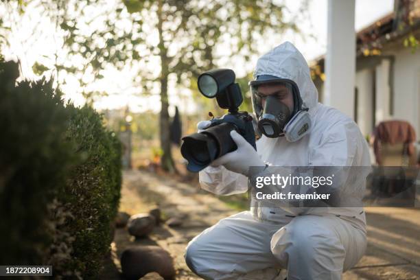 forensic scientist photographing evidence - forensisch stockfoto's en -beelden