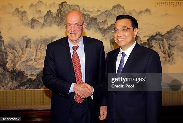 Former U.S. Treasury Secretary Henry Paulson shakes hands with China's Premier Li Keqiang during a meeting at the Zhongnanhai compound on November 7,...