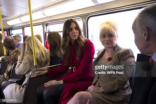 Catherine, Duchess of Cambridge rides with actress Barbara Windsor and Alastair Stewart on a 1960's Routemaster bus as as they meet staff and...