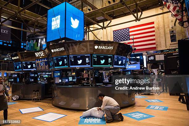 Worker unveils a floor mat bearing the logo of Twitter and the symbol on which Twitter's stock will traded on the floor of the New York Stock...