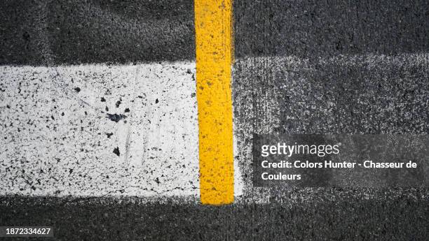 yellow and white lines painted and weathered on the textured asphalte of a street in montreal, quebec, canada - shapes stock pictures, royalty-free photos & images