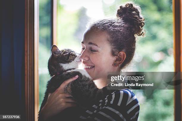 a girl and a cat hugging - girls cuddling cat stock pictures, royalty-free photos & images