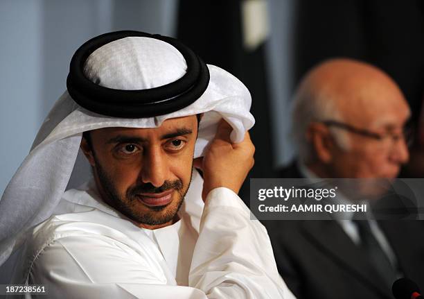 Visiting UAE Foreign Minister Abdullah bin Zayed al-Nahyan adjusts his scarf during a joint press conference with Pakistan's Adviser for National...