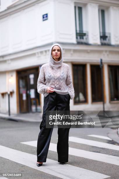 Maria Rosaria Rizzo wears a gray knit wool pullover with mesh parts and knitted geometric patterns and integrated hood from Les Boules Colorees,...