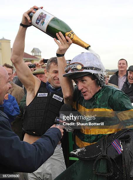 Tony McCoy riding Mountain Tunes is congratulated by fellow jockey Andrew Thornton after winning the Weatherbys Novices' Hurdle Race for his 4000th...