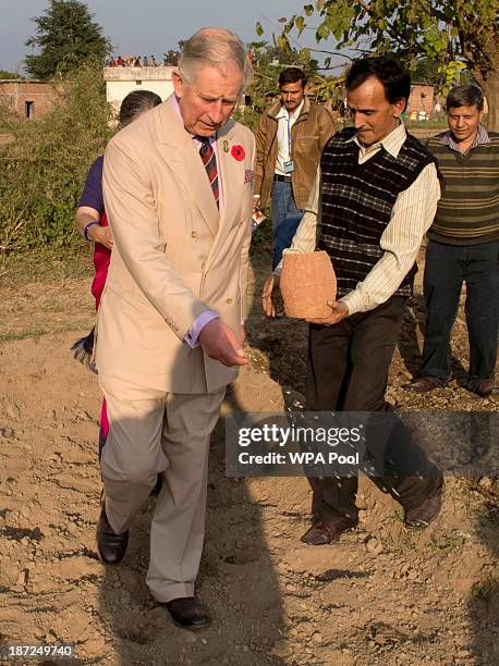 Prince Charles, Prince of Wales sows rice seeds during a visit to the Navdanya Organic Fam and Education Centre, an independent oraganisation that...