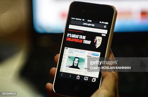 Activist hacker group Anonymous is seen through the internet government website of Singapore Prime Minister Office circulated online on a smartphone...