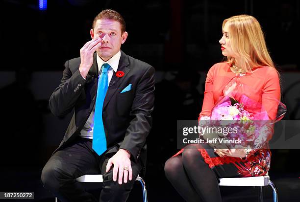 Former Vancouver Canuck Pavel Bure wipes his eye as he sits beside