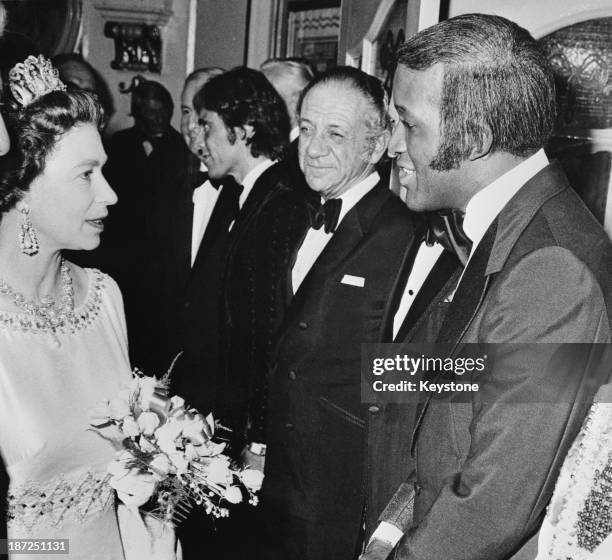 Queen Elizabeth II meets singer and performer Lovelace Watkins , English television presenter and entertainer Bruce Forsyth , South African actor and...