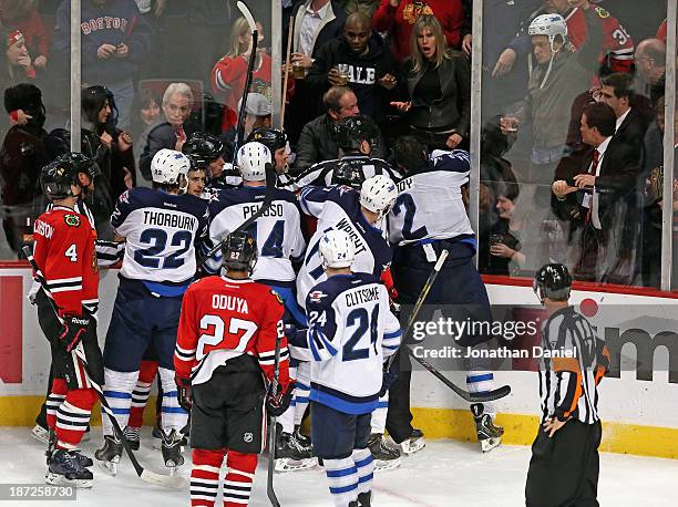 Fan wears the helmet of Adam Pardy of the Winnipeg Jets after pulling it off of his head after Pardy was checked through the glass by Brandon Bollig...