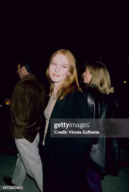 American actress and singer Alicia Witt, wearing a black coat over a beige sweater, attends the Los Angeles premiere of 'Hurlyburly', held at the...