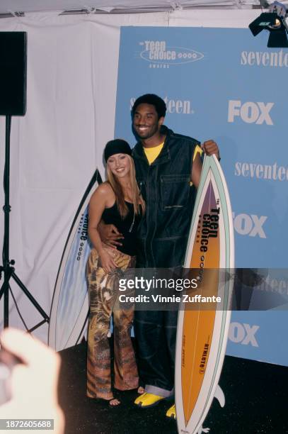 Mexican-American fashion model Vanessa Laine and American basketball player Kobe Bryant pose with a surfboard in the press room of the 2nd Annual...
