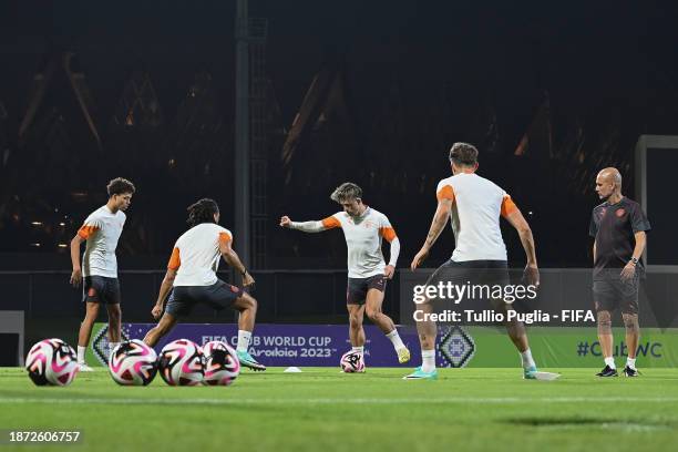 Jack Grealish and team mates warm up as Head Coach Pep Guardiola looks on during a Manchester City training session ahead of the FIFA Club World Cup...