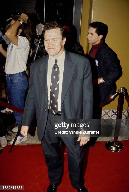 American actor Michael Rooker, wearing a dark blue suit with a white shirt and a dark blue-and-white tie, attends the Westwood premiere of 'JFK',...