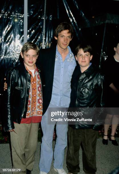 American actor Lukas Haas wearing a pinstripe jacket over a blue embroidered shirt, and his brothers, twins Nikki Haas and Simon Haas, attend a...