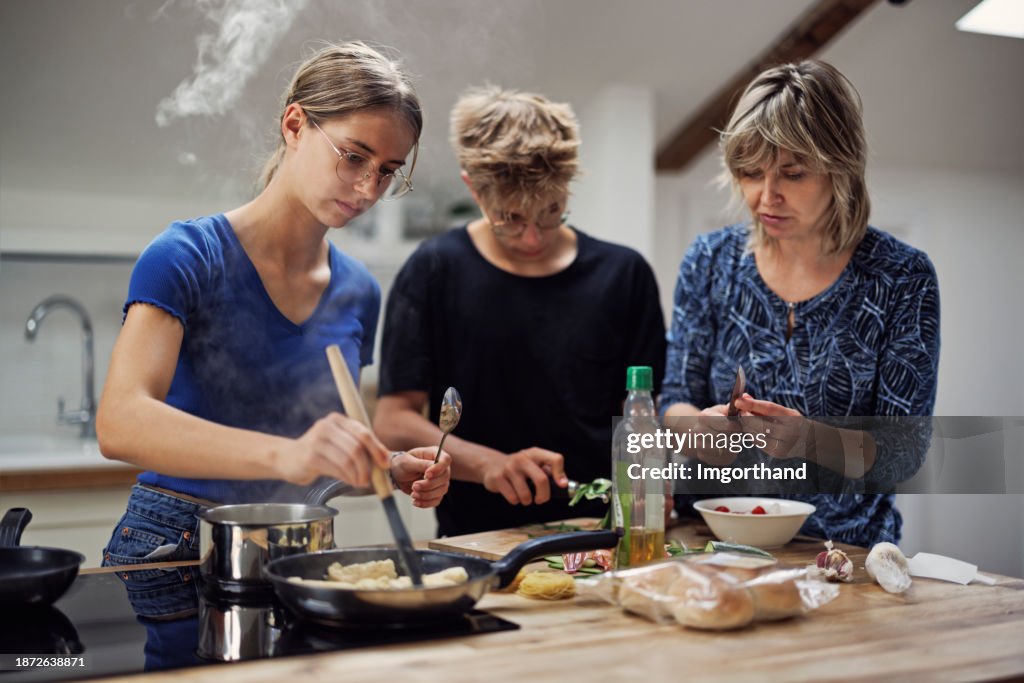 Mother and teenagers preparing a quick lunch in the kitchen