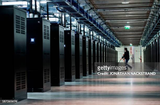 An employee walks past servers at the new Facebook Data Center, its first outside the US on November 7, 2013 in Lulea, in Swedish Lapland. The...