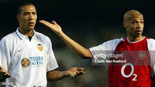 Thierry Henry of Arsenal with John Carew of Valencia show they are the same colour to try to calm the fans down after Thierry Henry gets racial abuse...