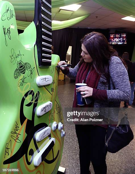 Hillary Scott of Lady Antebellum signs a giant Patron tequila guitar backstage at the CMA Awards to benefit the "Keep the Music Playing" music...